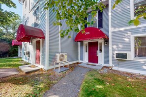 Classic two-story residence with a red awning and a well-manicured lawn.