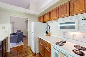 Enjoy cooking in this well-equipped kitchen with a refrigerator, microwave, and stove, plus ample storage and a dining area.