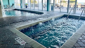Een binnenzwembad met betegelde vloer, helder water en een bordje 'No Diving'.