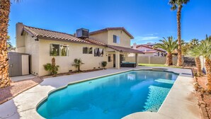 A house with a swimming pool, palm trees, and a clear blue sky. - The  Oasis (Las Vegas)