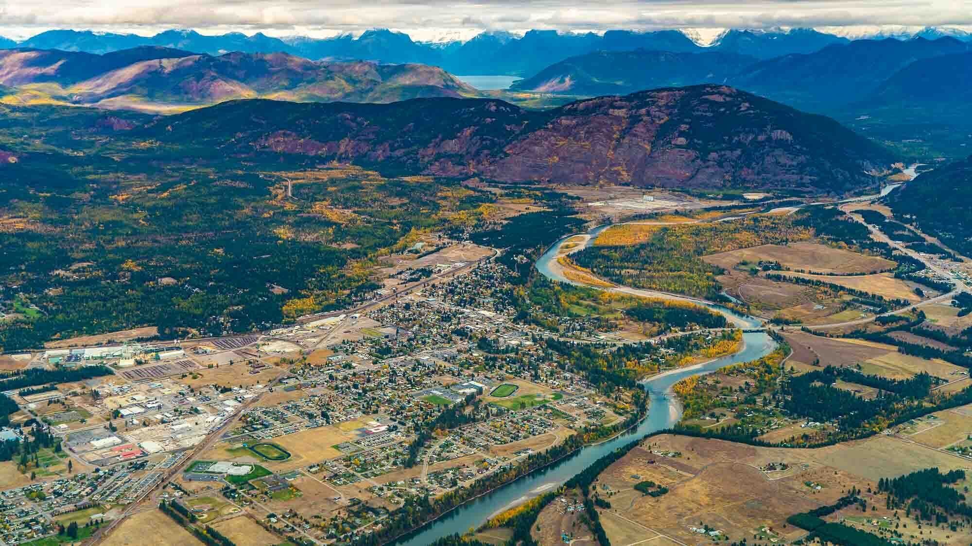 Ein Luftbild einer Stadt, durch die ein Fluss fließt, umgeben von Bergen.