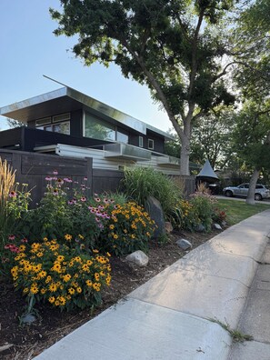 A modern house with a large window, a tree, and a garden with flowers. - Beautiful remodeled home in North Boulder - Close to Sundance Films (Boulder)