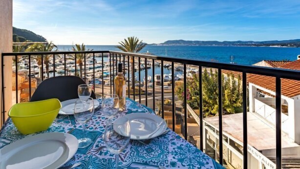 A table set for dining with a view of the sea and boats. - La Corniche by Interhome (Saint Cyr sur Mer La Madrague)
