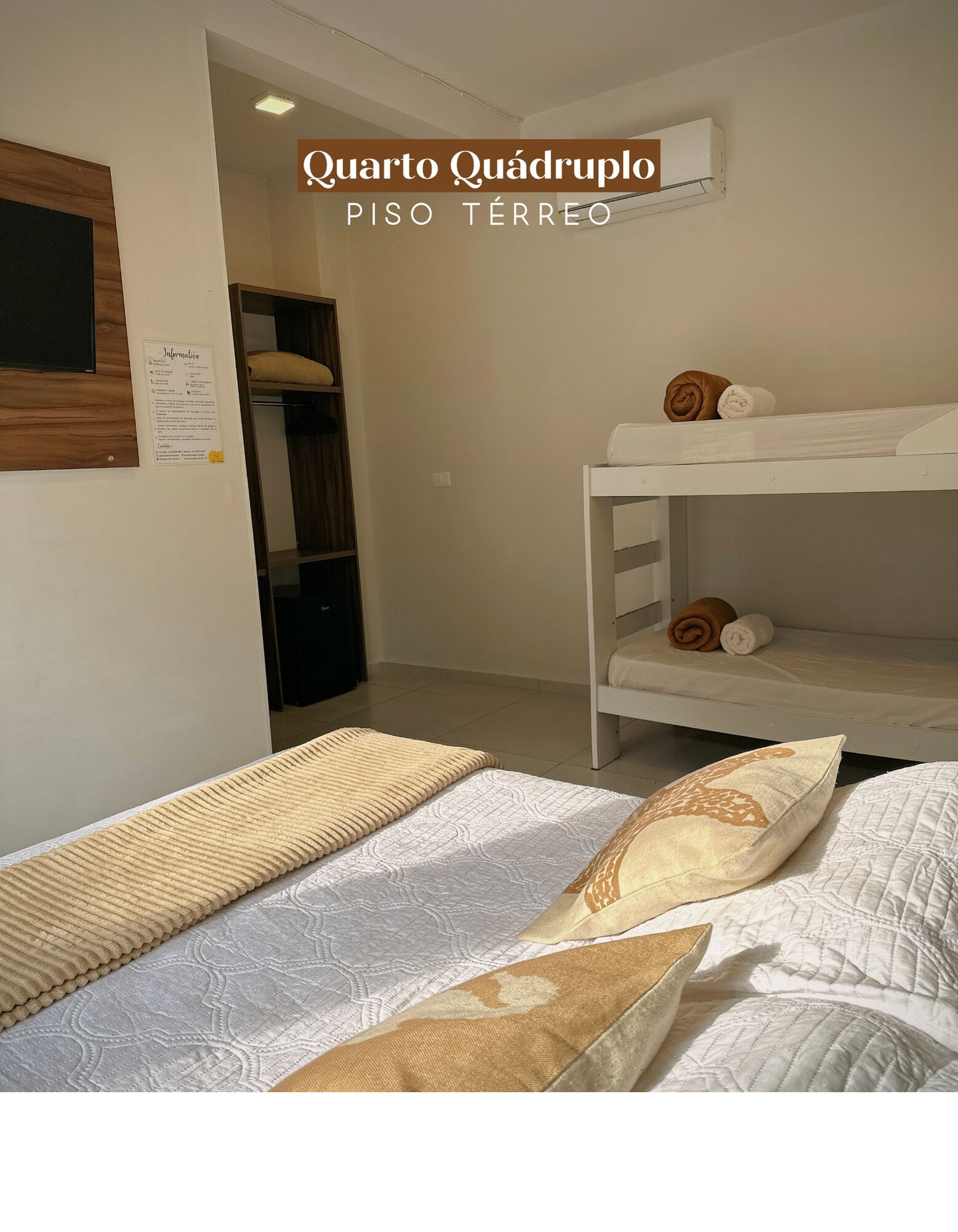 A room with bunk beds, a wooden wardrobe, and a bulletin board.