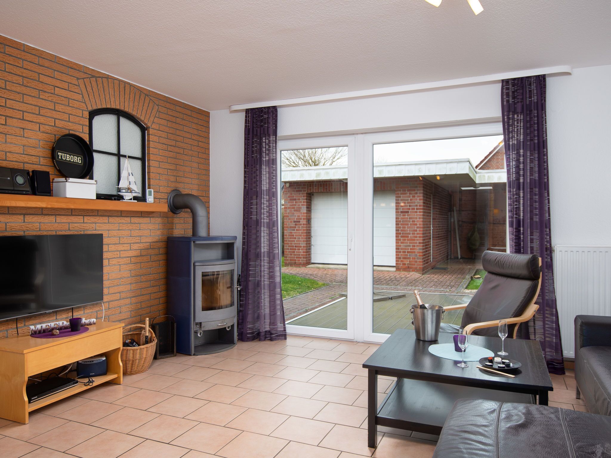 Ein Wohnzimmer mit Fernseher, Kamin, Sofa und Esstisch.