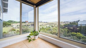 Una habitación con ventanas amplias que ofrecen vistas a un paisaje verde y edificios.