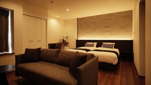 Ein modernes Schlafzimmer mit einer Couch, einem Bett und einem Schreibtisch.