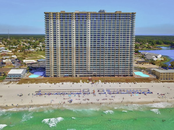 A high-rise hotel with multiple balconies, a beach, and a pool area. - TideWater Beachfront 2 Bedroom 3 Bathroom, Plus Twin Bunk Bed (Panama City Beach)