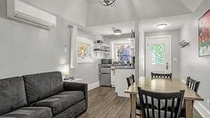 Una cocina moderna con armarios blancos, un microondas y un refrigerador.