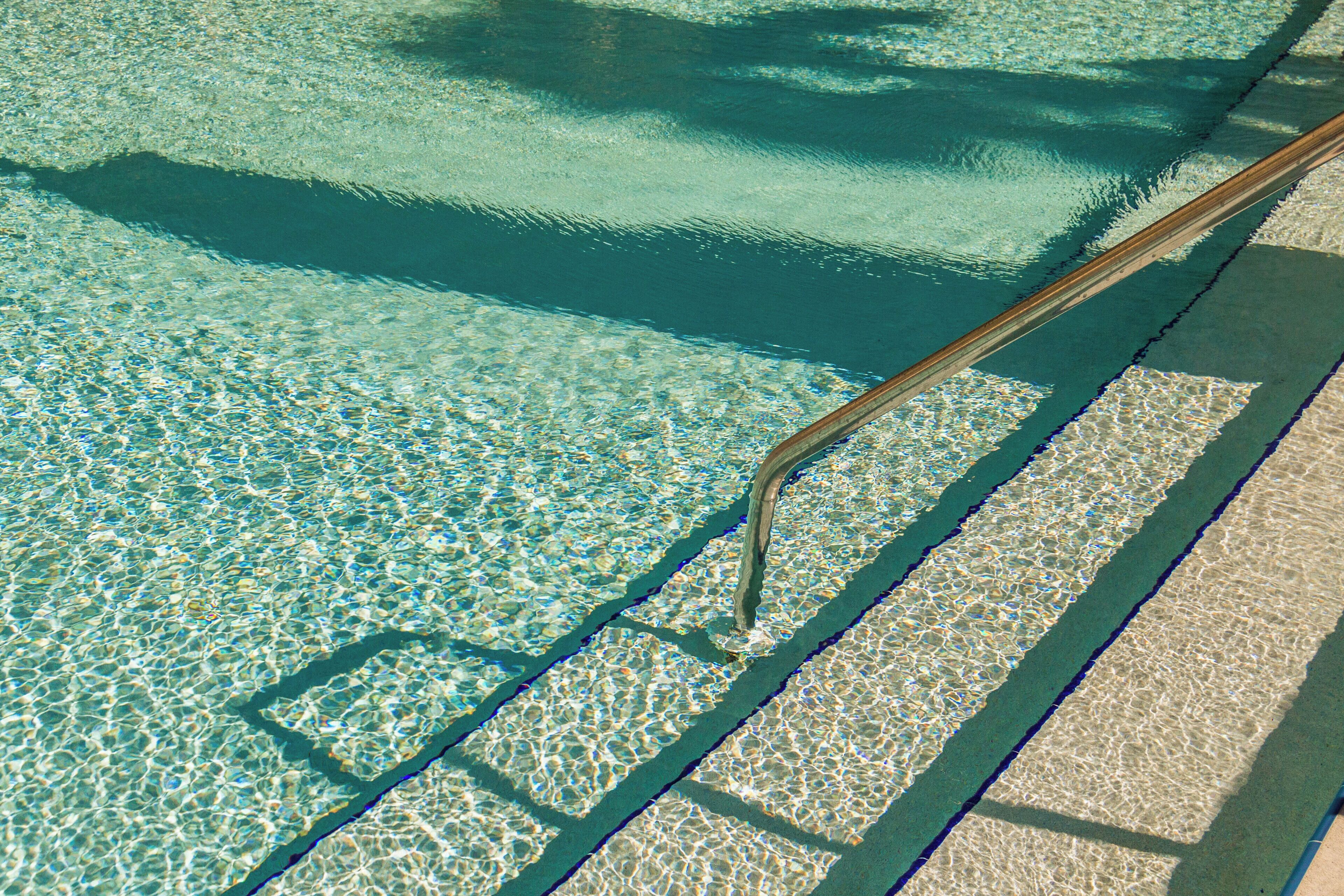 Ein klares Schwimmbecken mit sichtbarer Leiter und Treppen.