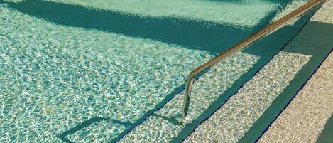Ein klares Schwimmbecken mit sichtbarer Leiter und Treppen.