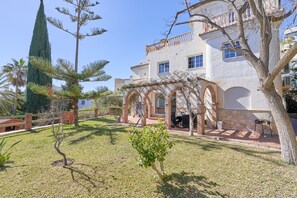 Un edificio con fachada blanca, ventanas arqueadas y un balcón.