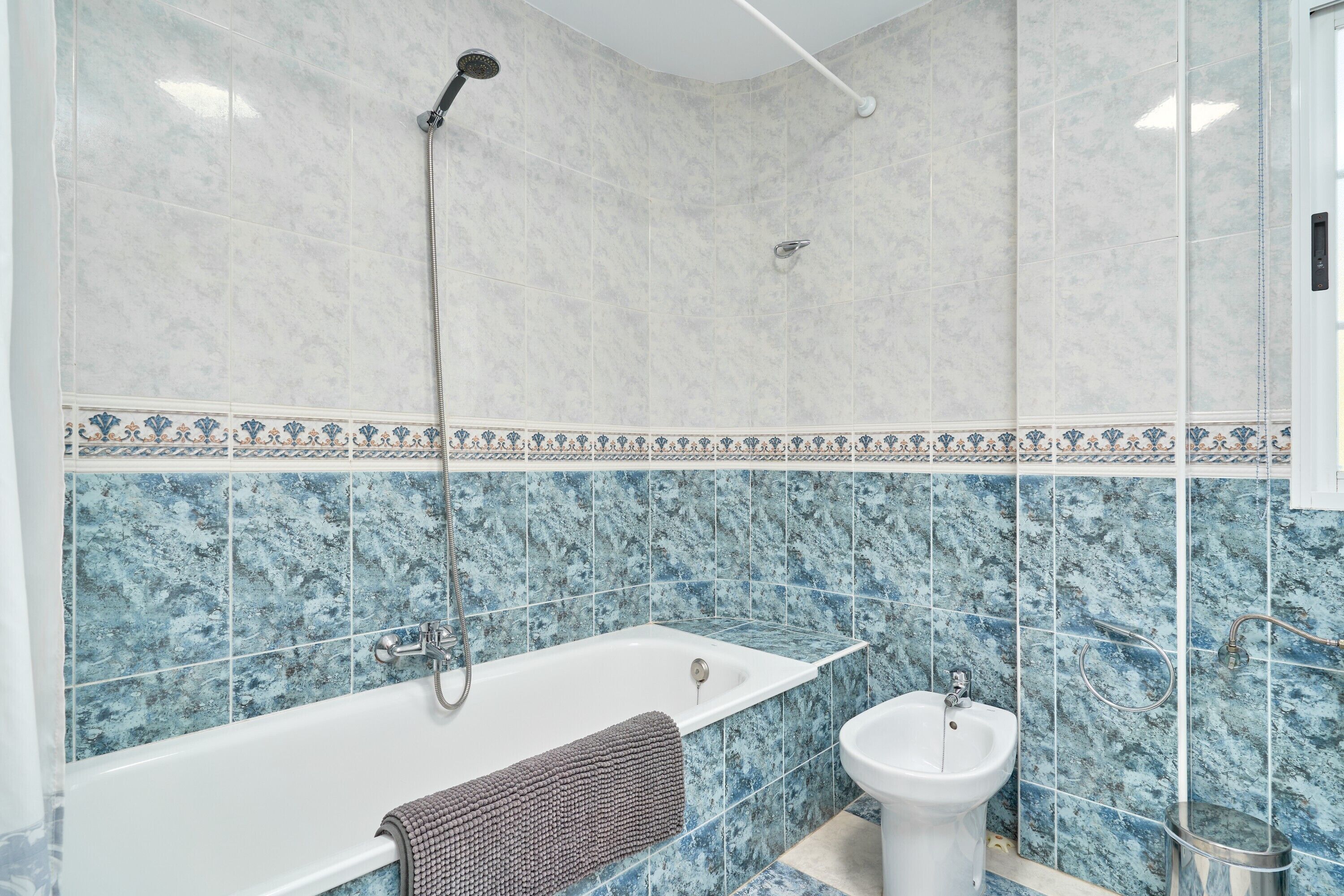 A bathroom with a bathtub, shower, and bidet.