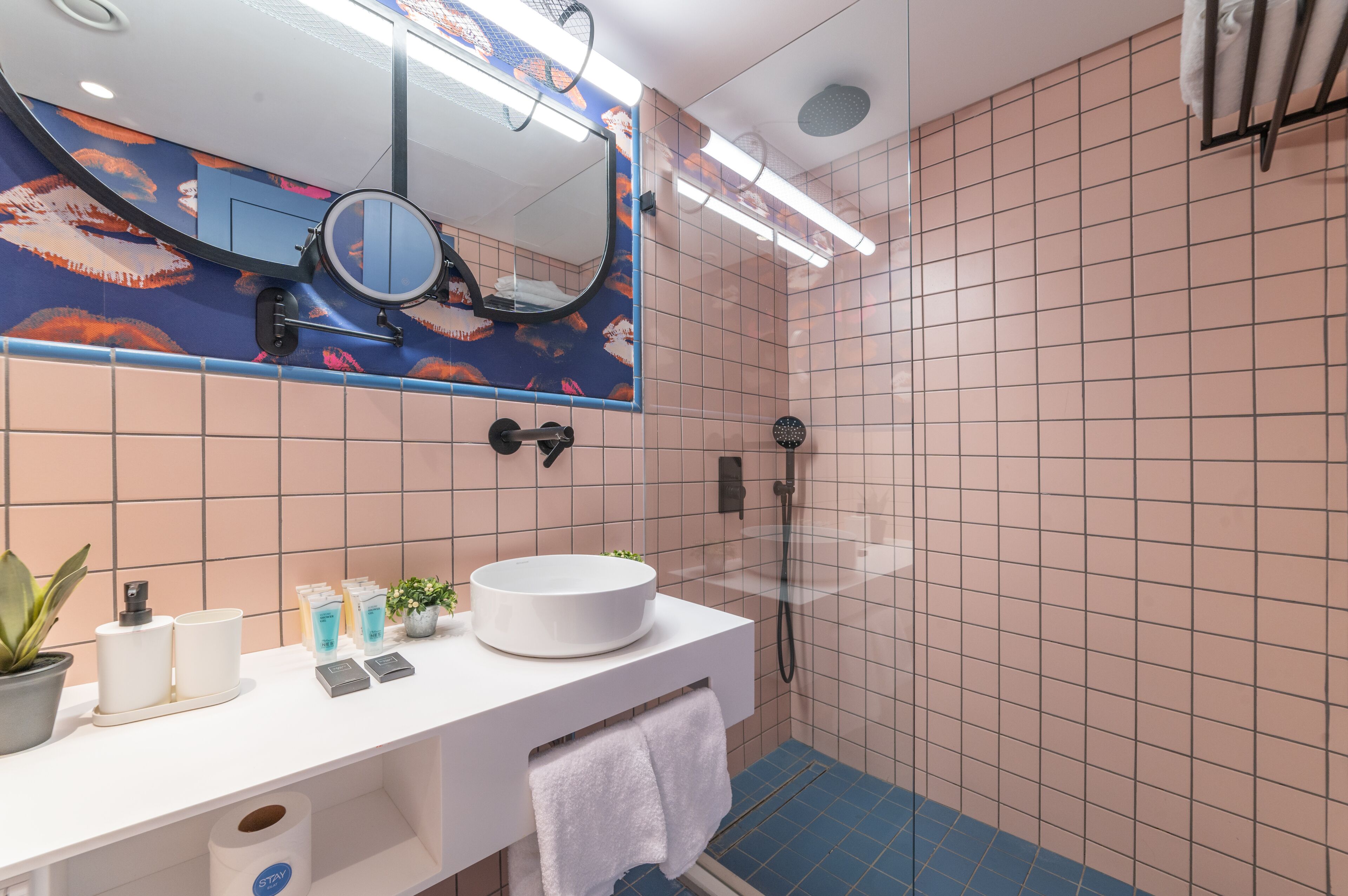 A bathroom with a round sink, a mirror, and a shower.