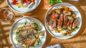 Tres platos de comida sobre una mesa de madera.