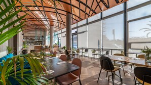 Un espacio interior amplio con techos altos, ventanas grandes y muebles modernos.