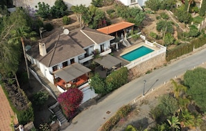 Une maison à deux étages dotée d’une piscine, d’un patio couvert et d’un escalier menant à l’étage supérieur.