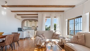 Un salon comprenant un canapé, une table basse et un coin repas avec des chaises.