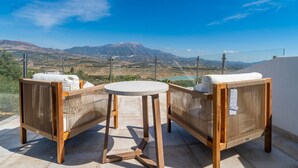 A terrace with two wicker chairs and a small round table, overlooking a mountainous landscape. - Villa Las Alondras with Lake and Mountain View, Pool, Garden & Wi-Fi (La Viñuela)