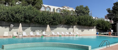 Piscina externa sazonal, funciona das 9h às 18h, guarda-sóis