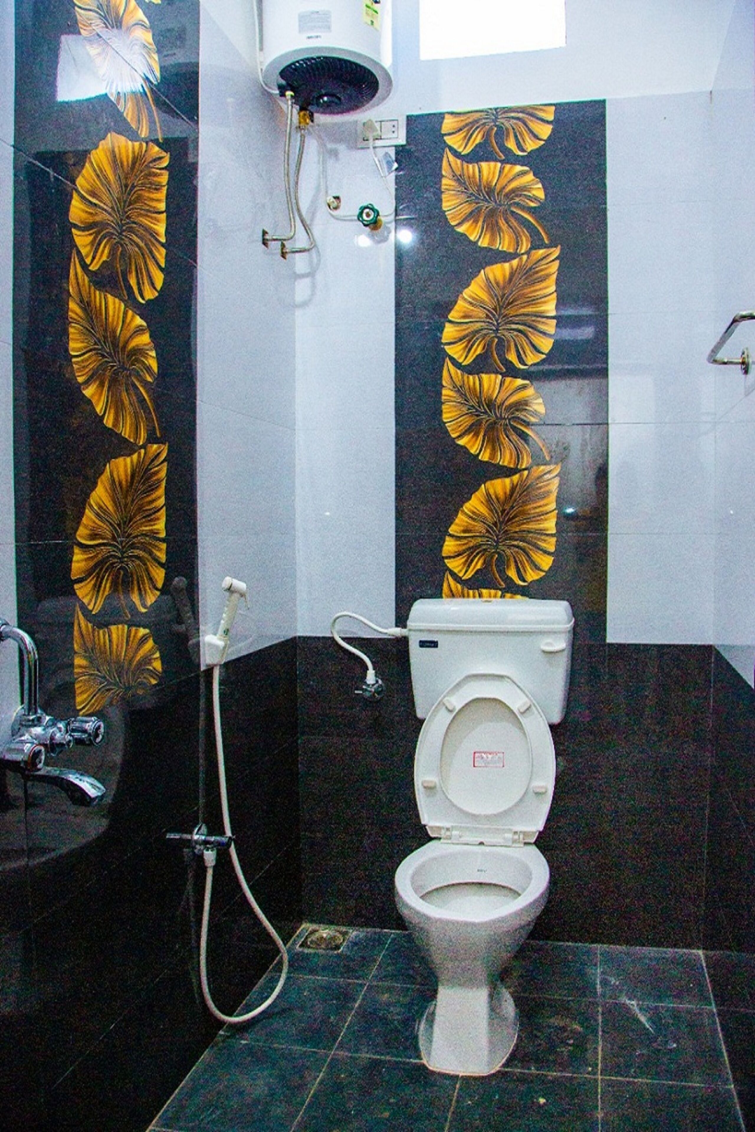 A bathroom with a toilet, a shower, and a wall with a floral pattern.