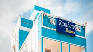 A multi-story building with a blue and white exterior, a sign reading "Rainbow Residency," and balconies with railings. - Rainbow Residency ECR (Vanur)