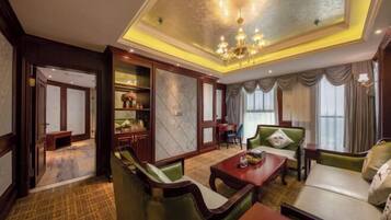 A spacious living room with a chandelier, a sofa, a coffee table, and a dining area.