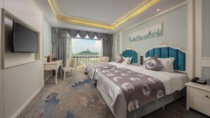 Une chambre d’hôtel avec un grand lit, un téléviseur fixé au mur, un bureau et une chaise.