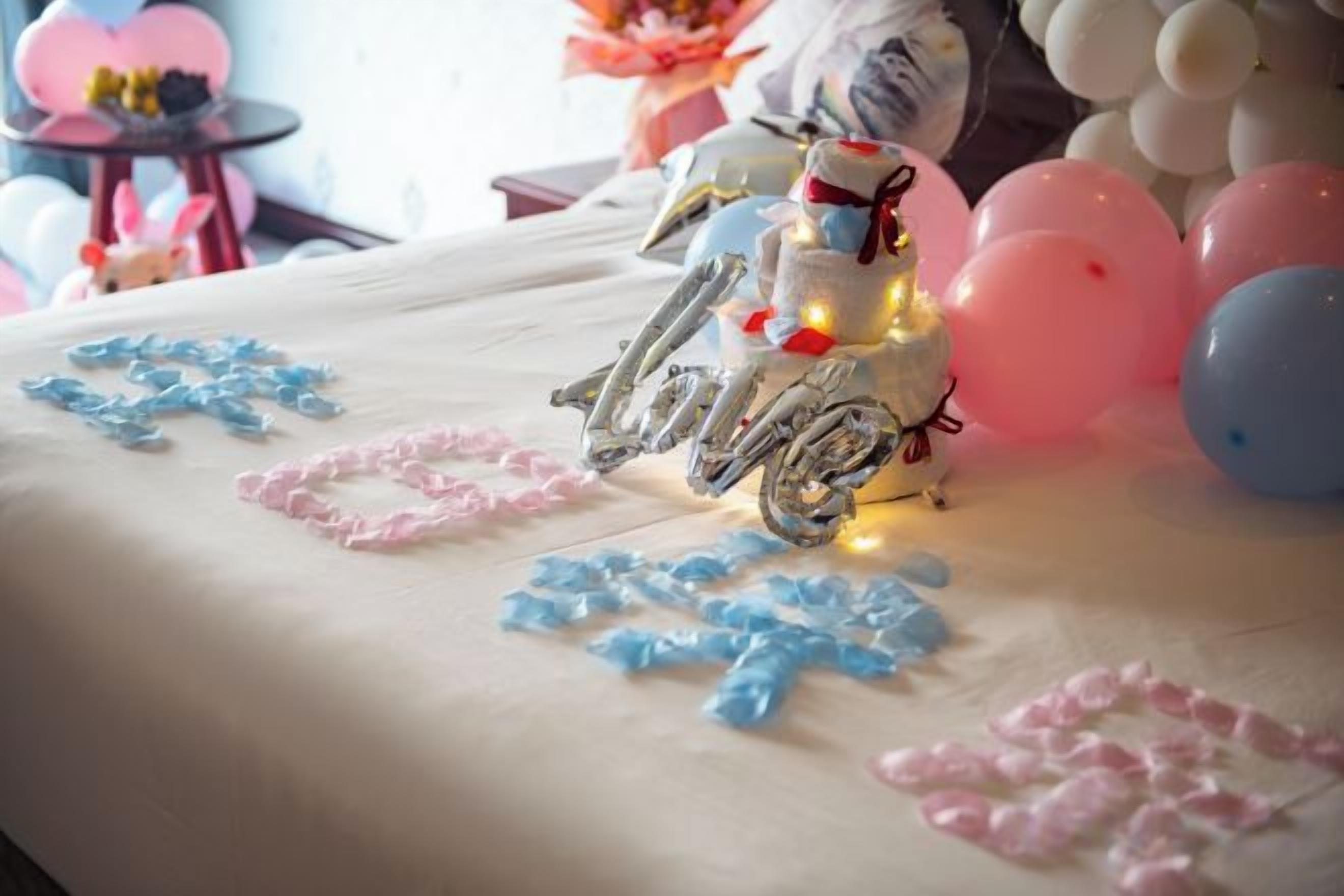 Un tavolo decorato con una torta, palloncini e una decorazione a forma di motocicletta.