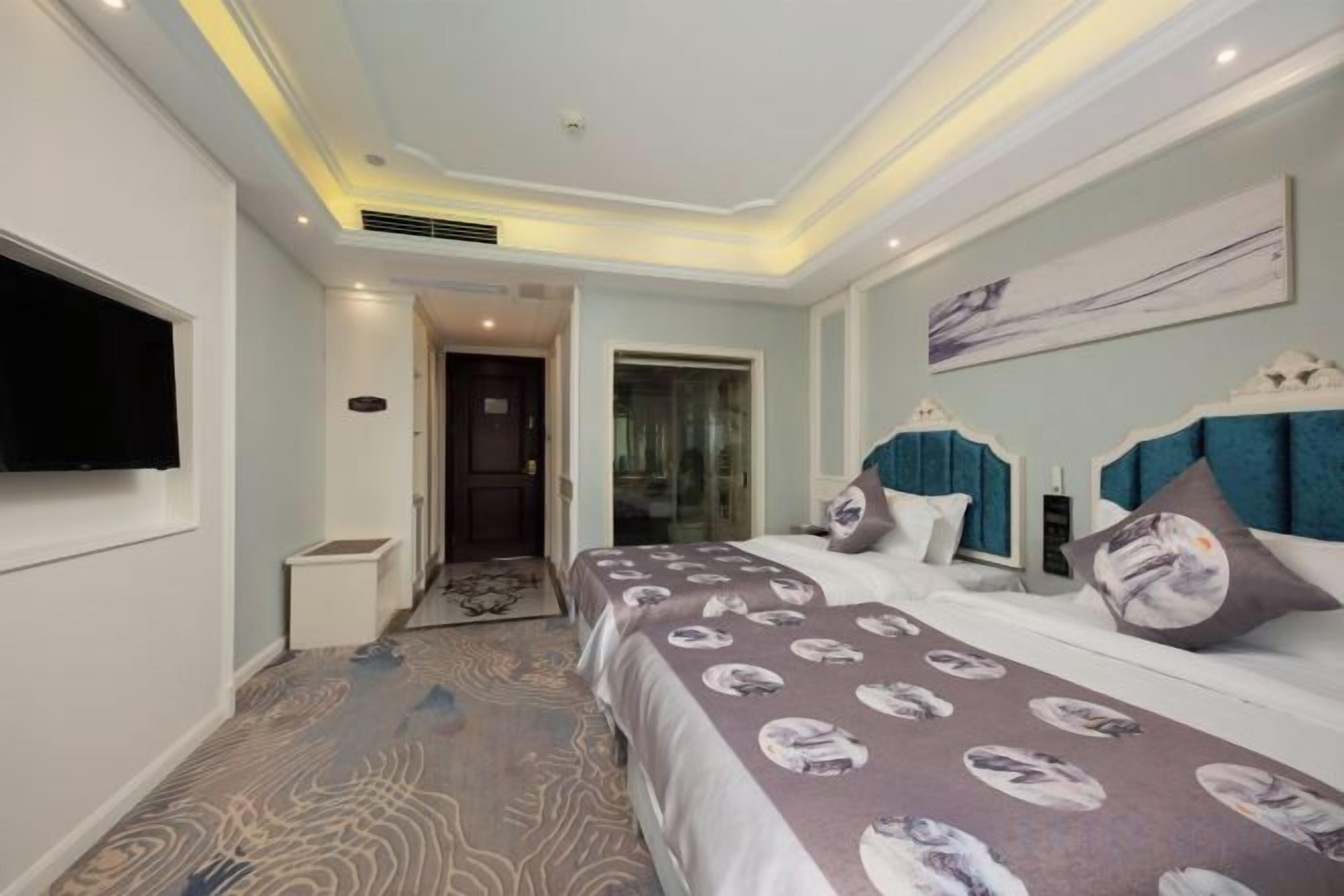 A hotel room with a large bed, a television mounted on the wall, and a door leading to a bathroom.