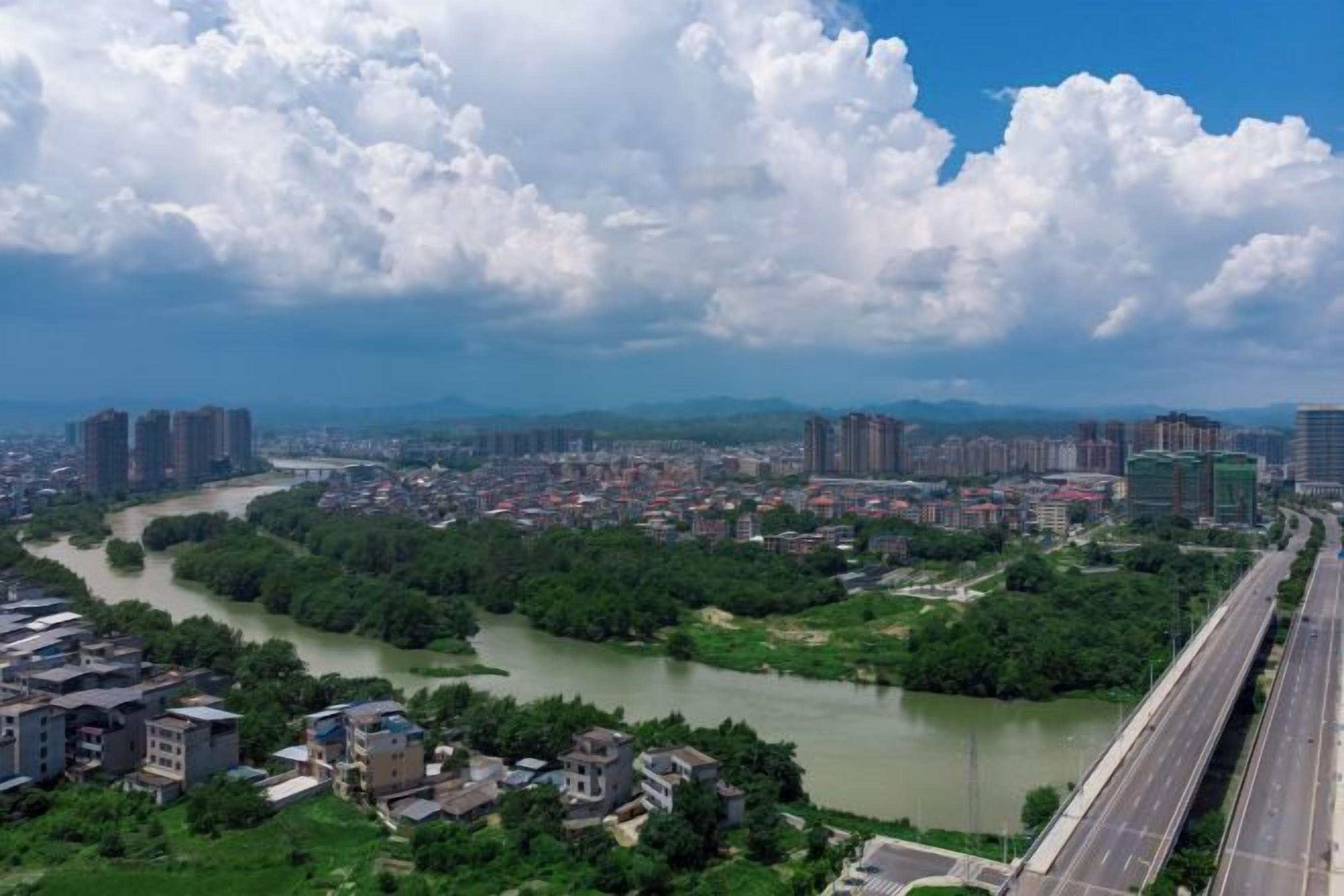 Une rivière traverse une ville où se trouvent des immeubles et une autoroute.