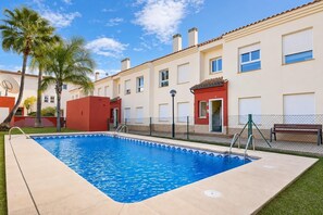 A swimming pool with a tiled edge, surrounded by a fence, with a building in the background. - Tigre - Jesus Pobre, Costa Blanca (Jesus Pobre)