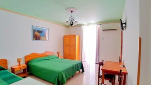 Una camera da letto con un letto, una scrivania, un armadio e un quadro appeso al muro.