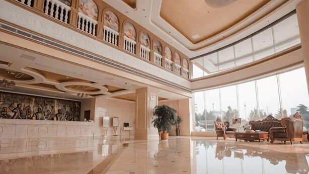 Un'ampia hall con soffitto alto, una reception e un'area salotto.
