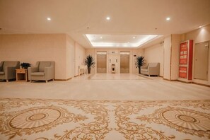A hotel lobby with a patterned carpet, seating area, and a reception desk. - Yunxuan Hotel (Linyi Chengxu Mansion) (Tancheng)