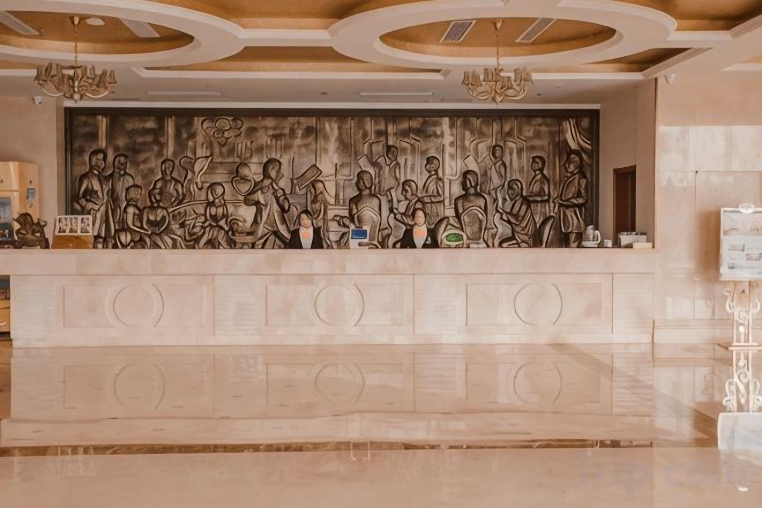 A reception desk with a detailed relief sculpture above it.