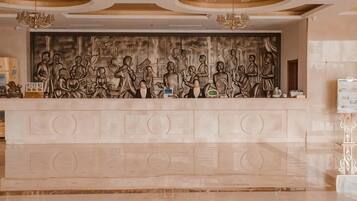 A reception desk with a detailed relief sculpture above it.