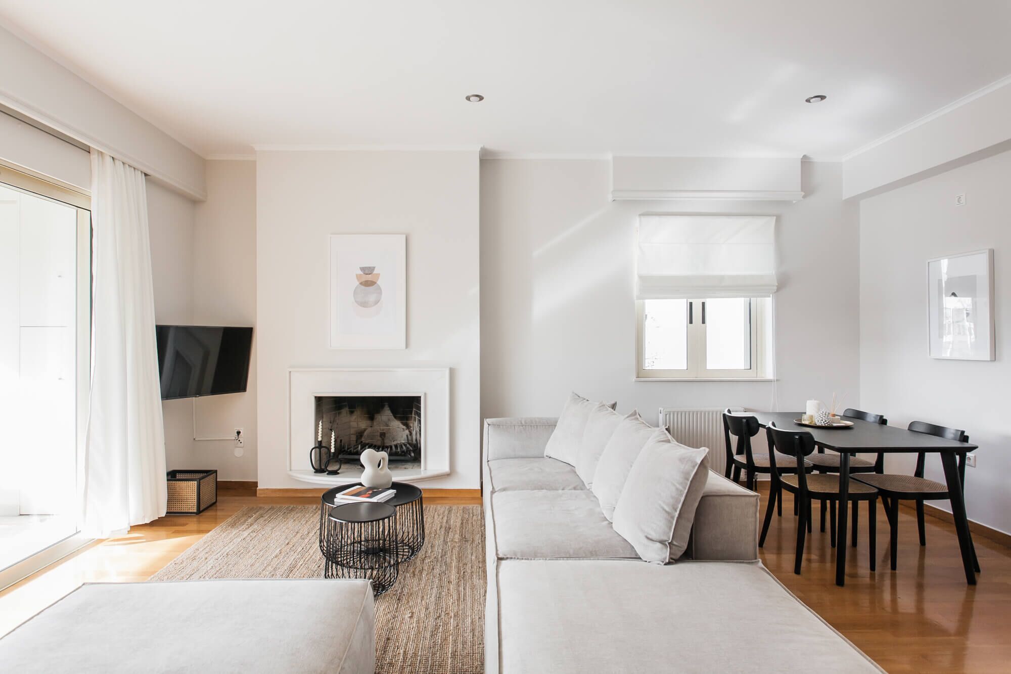Uma sala de estar moderna com lareira, sofá, mesa de jantar e cadeiras.