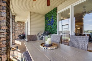 Une terrasse extérieure avec une table, des chaises, un barbecue et un récipient en verre décoratif.