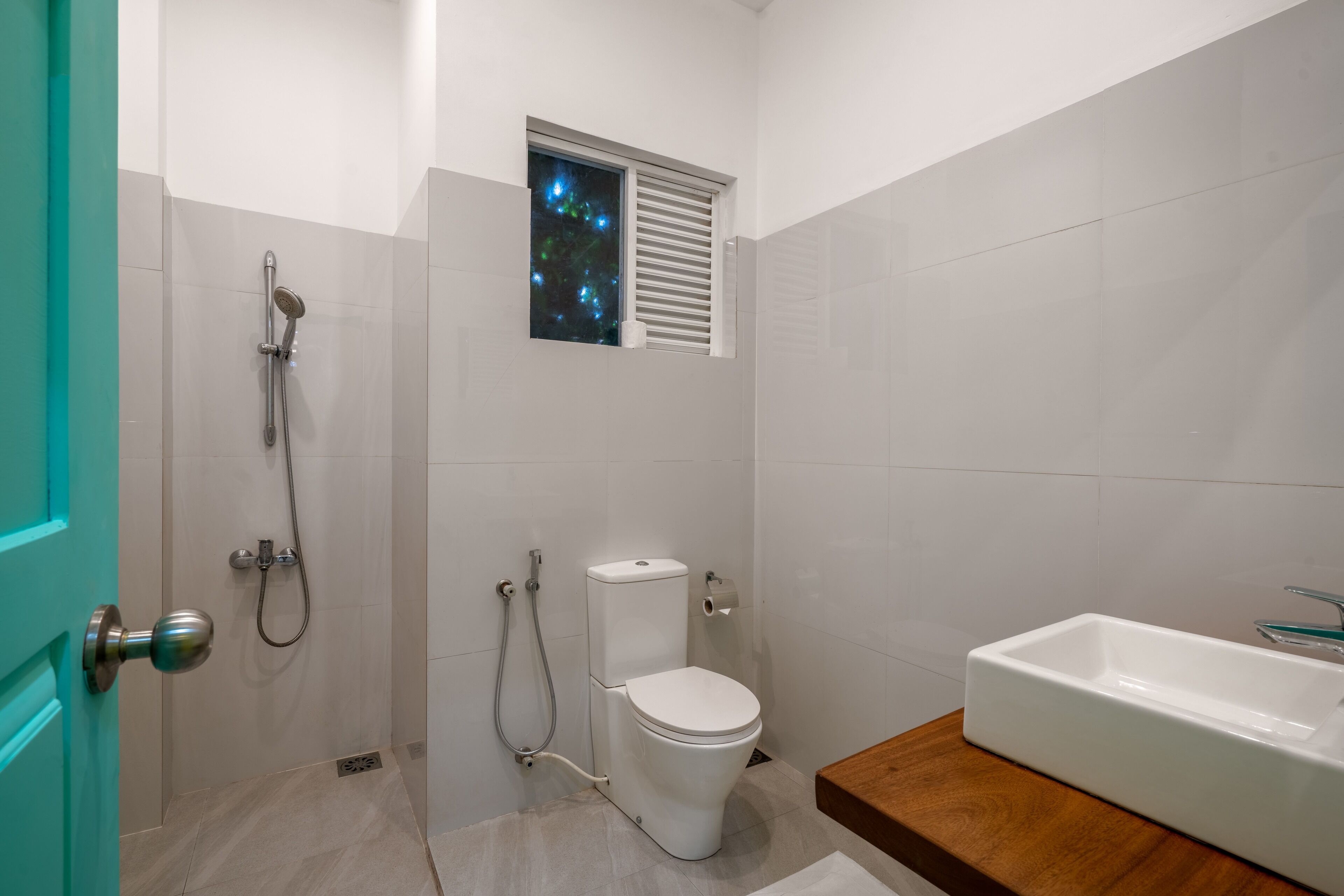 A modern bathroom with a toilet, shower, and sink.