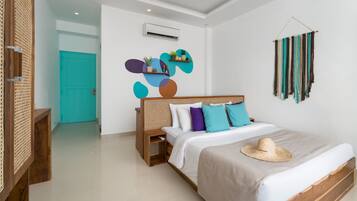 A modern bedroom with a wooden bed, white bedding, a teal door, and abstract wall art.