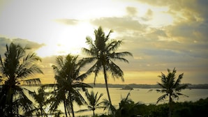 A coastal view with palm trees and a sunset. - Outpost Weligama Beachfront (Weligama)
