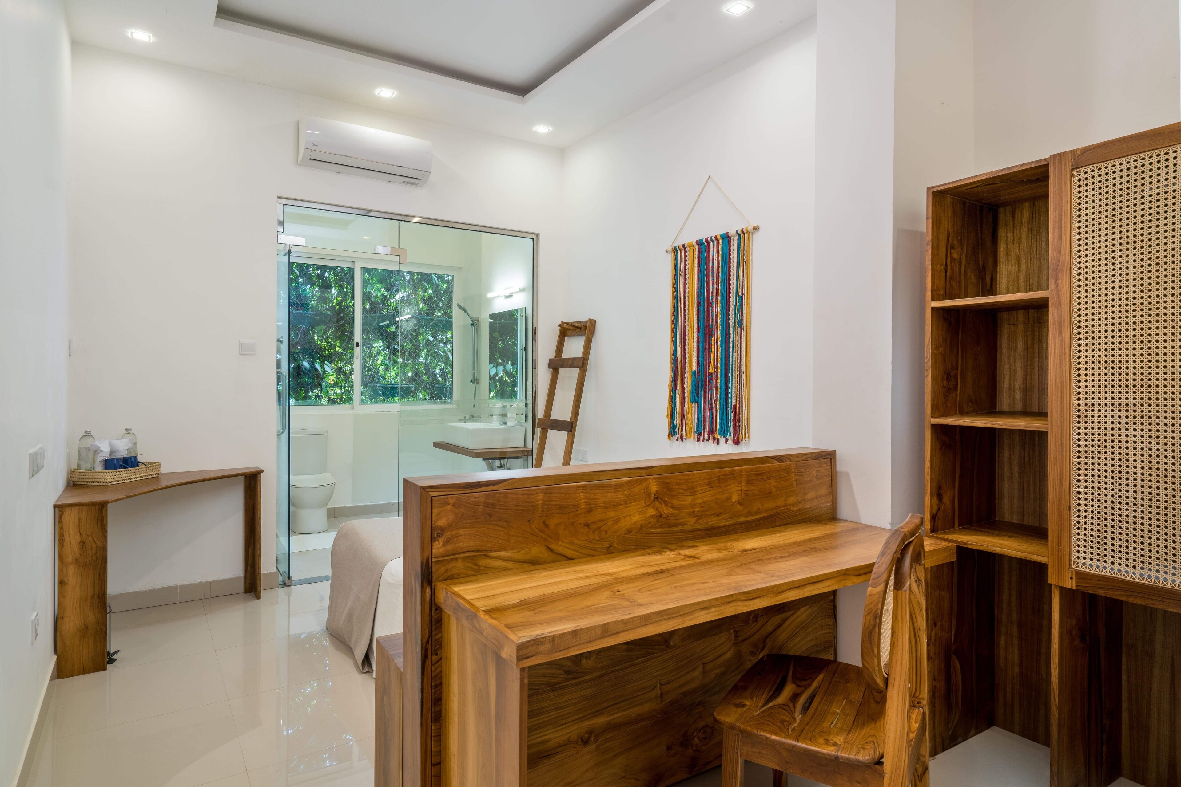 A modern bathroom with a wooden vanity, a glass shower enclosure, and a wooden shelf unit.