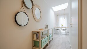 A hallway with a light wooden floor, a green storage unit, and two wall-mounted mirrors. - Quartier 7, App. 16, Germany (Heringsdorf)