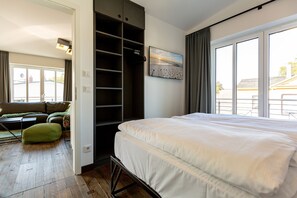 Quarto com uma cama grande, um closet espaçoso e vista através de uma janela ampla.