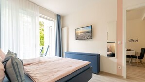 Et moderne soveværelse med en seng, et skrivebord og en stol.