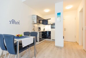 A compact kitchen with modern appliances, a dining area with a table and chairs, and a small kitchenette.