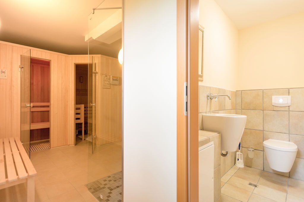 Une salle de bain comprenant des toilettes, un lavabo et un espace douche.