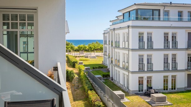 En moderne bygning med balkon, havudsigt og velholdt græsplæne.