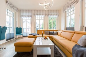 A modern living room with a sofa, ottoman, and a coffee table.